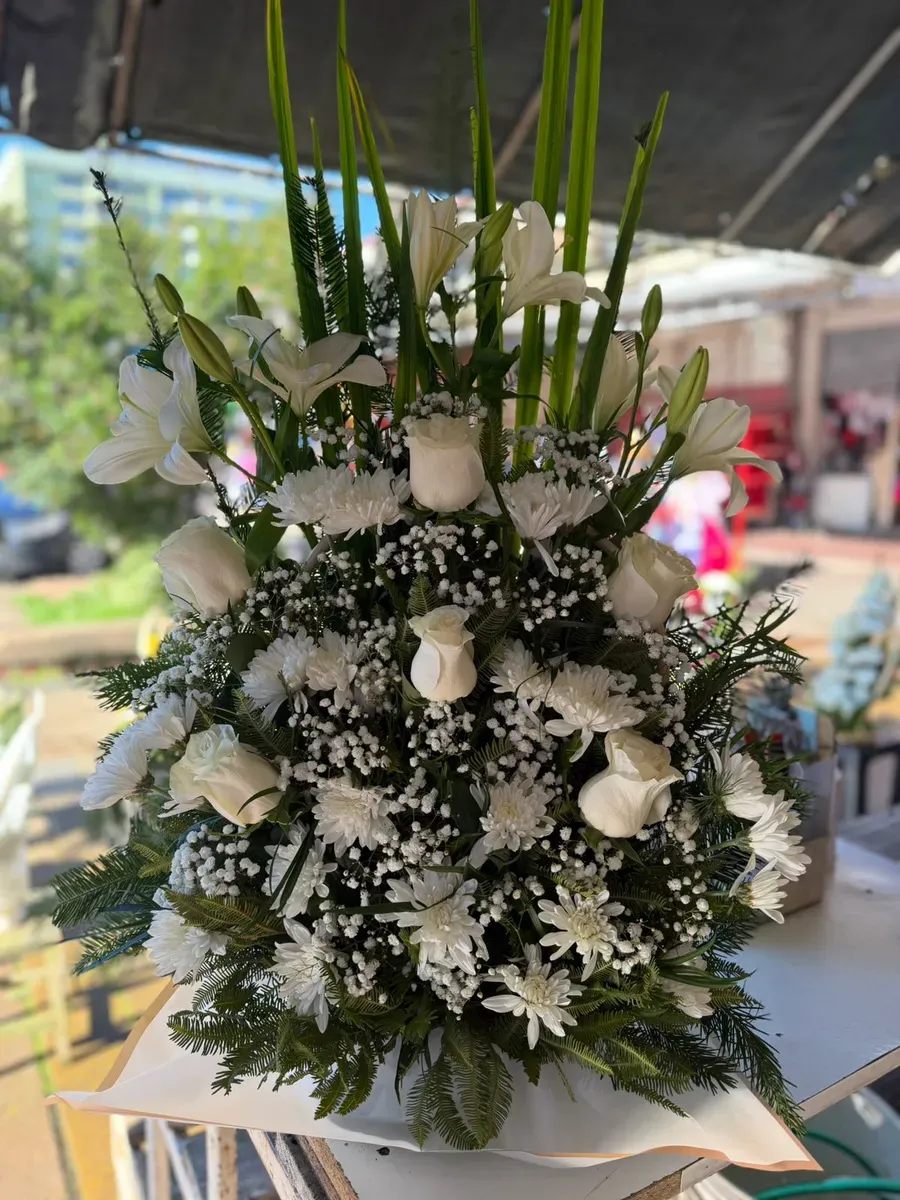 Canastillo Gold de gran volumen con flores blancas y follaje verde
