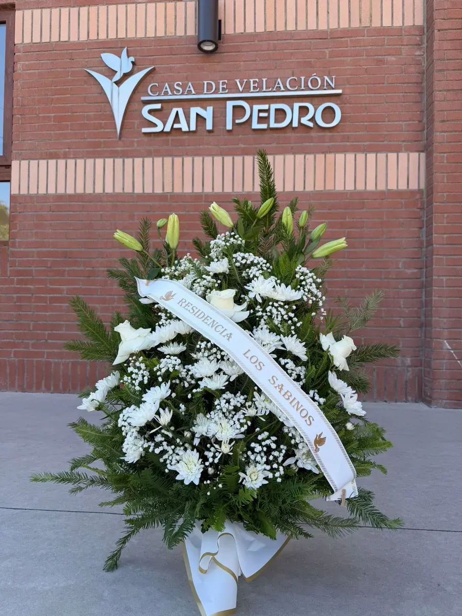 Pie de urna clásico con flores blancas y cinta de condolencias