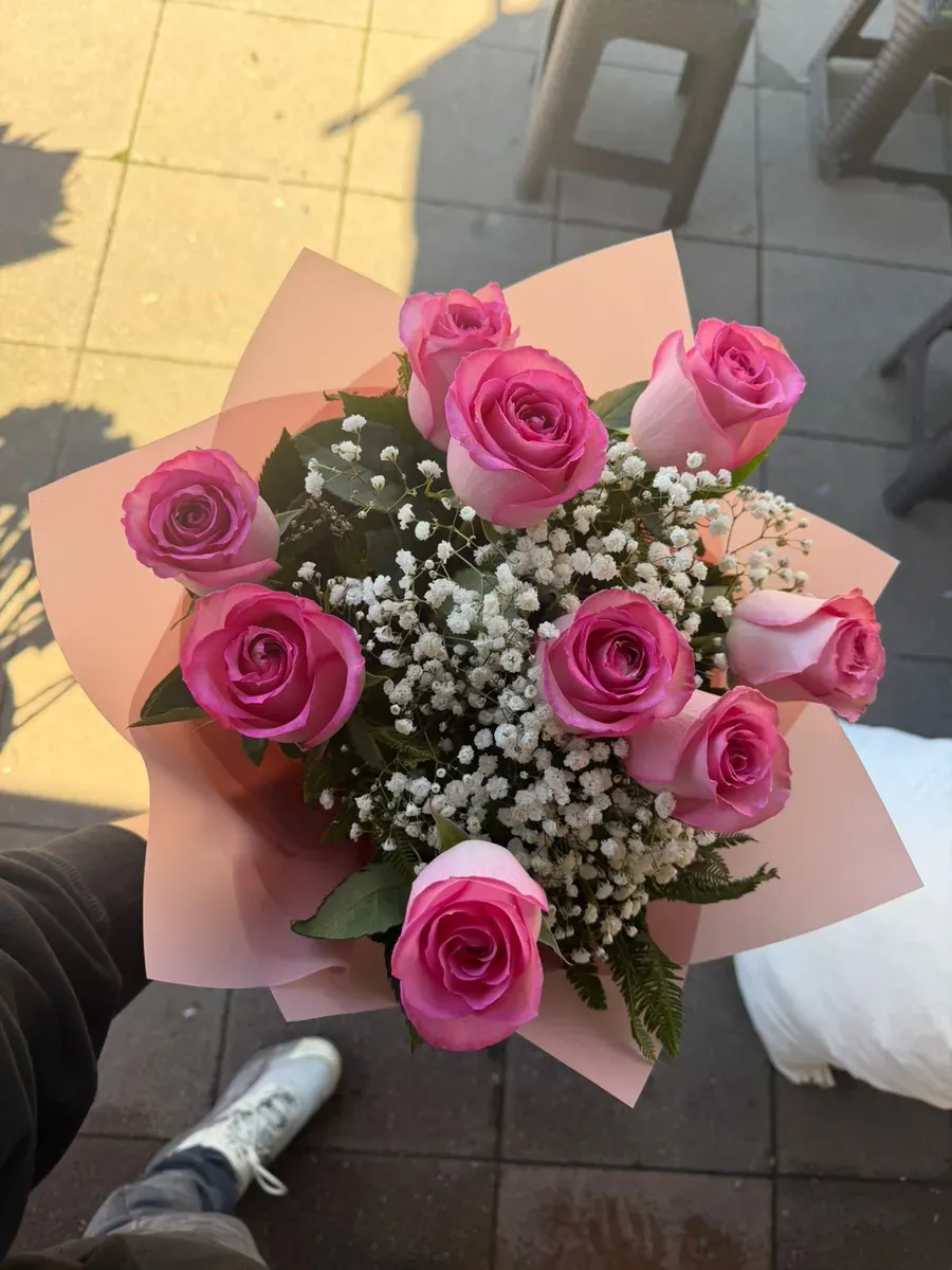 Ramo de nueve rosas rosadas con gypsophila y envoltorio rosado