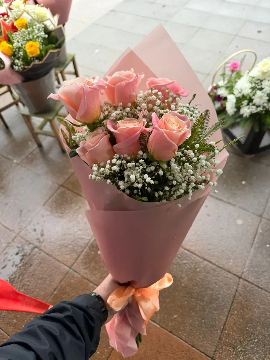 Ramo de rosas rosadas con gypsophila y envoltorio rosado